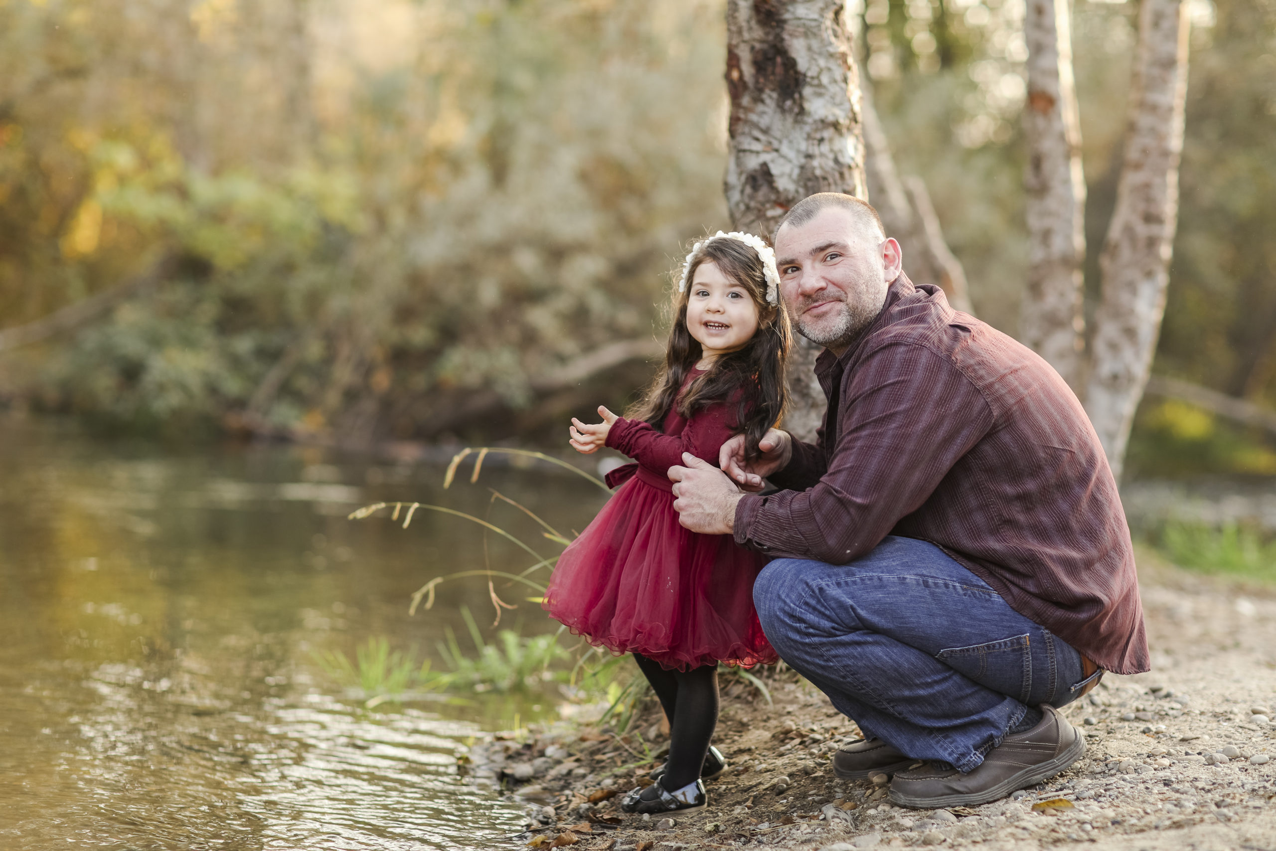 father and daughter playing by a river