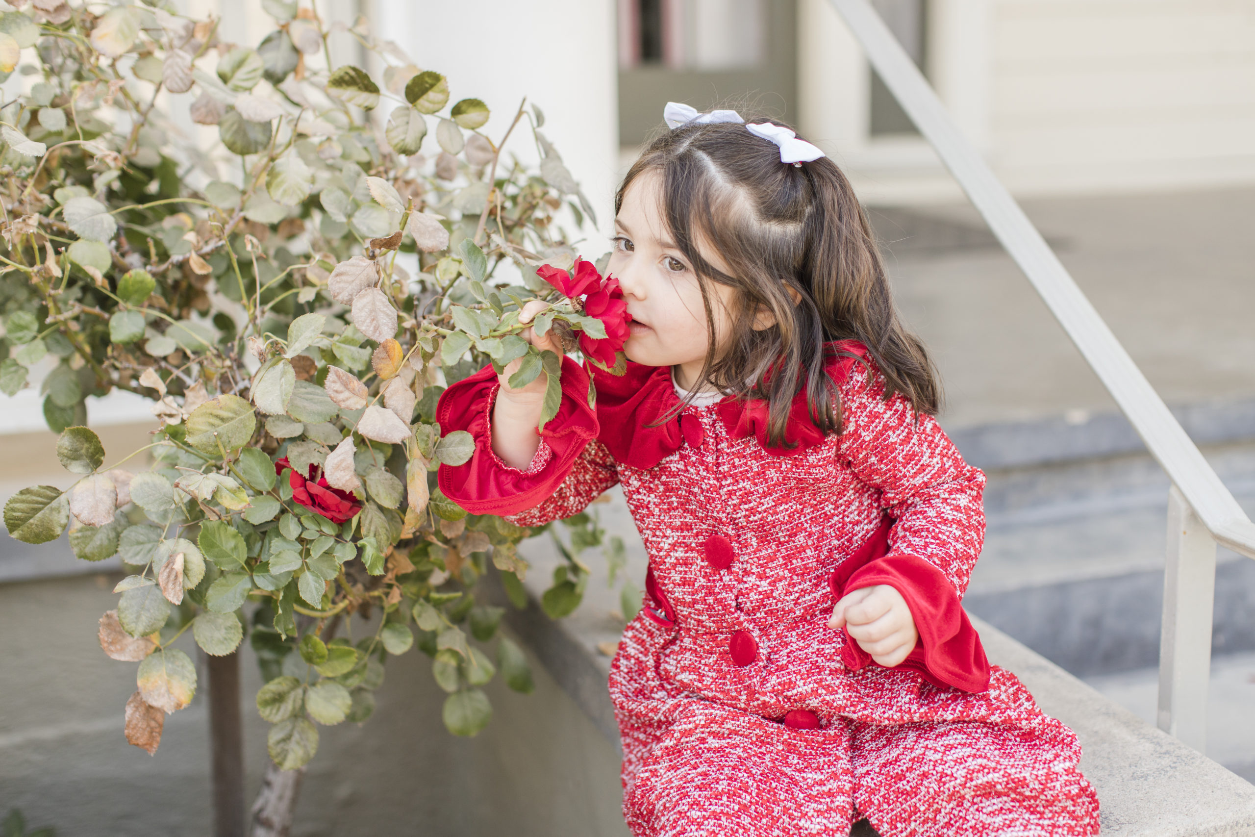 little girl smelling a flower