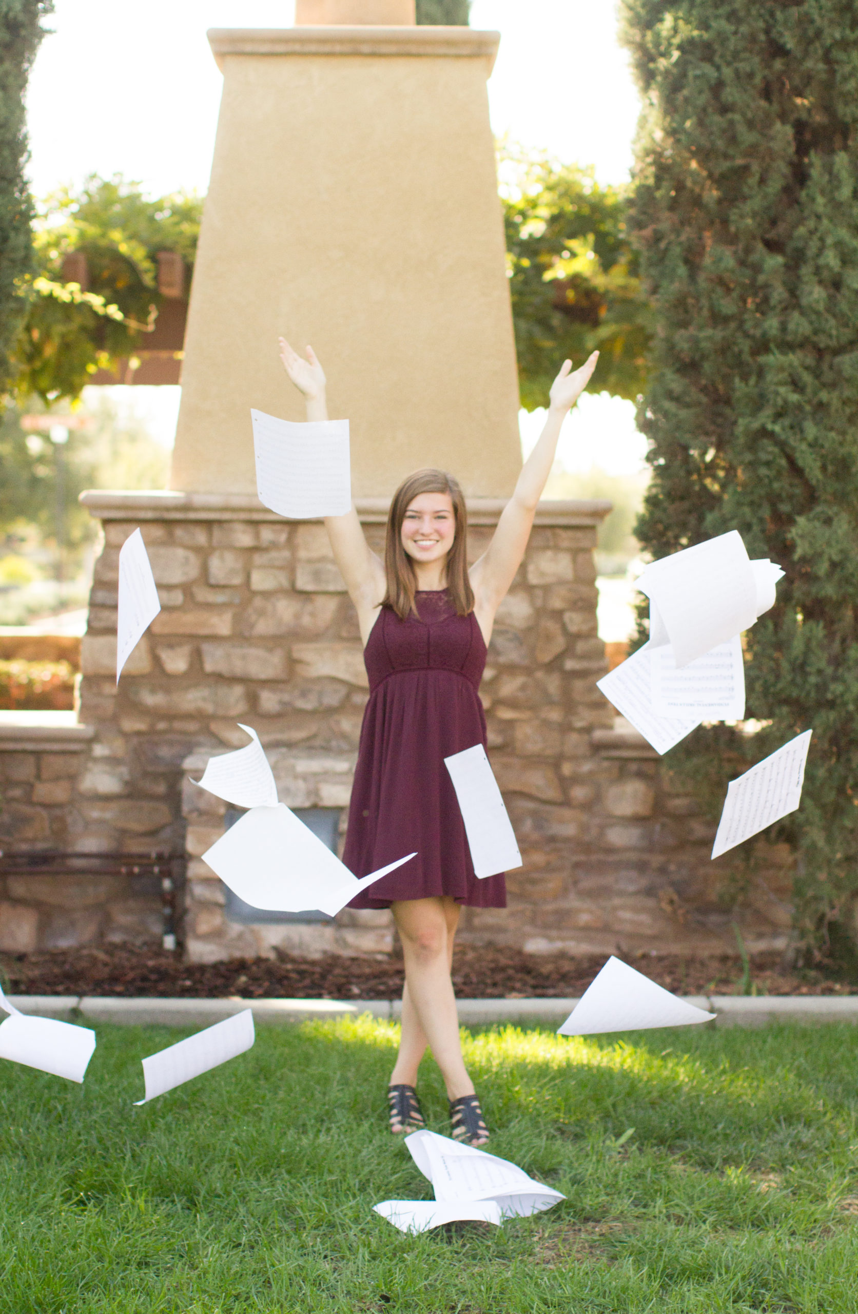 why you need senior portraits girl throwing paper