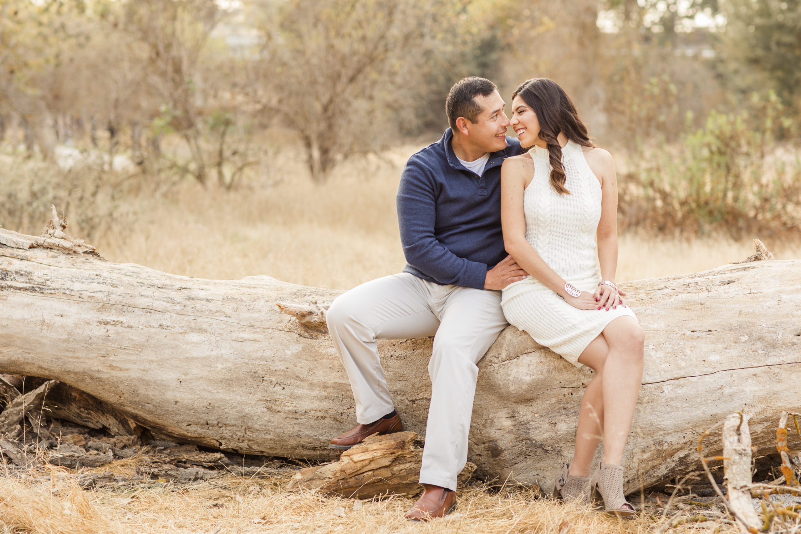 choosing engagement outfits for couple sitting on log
