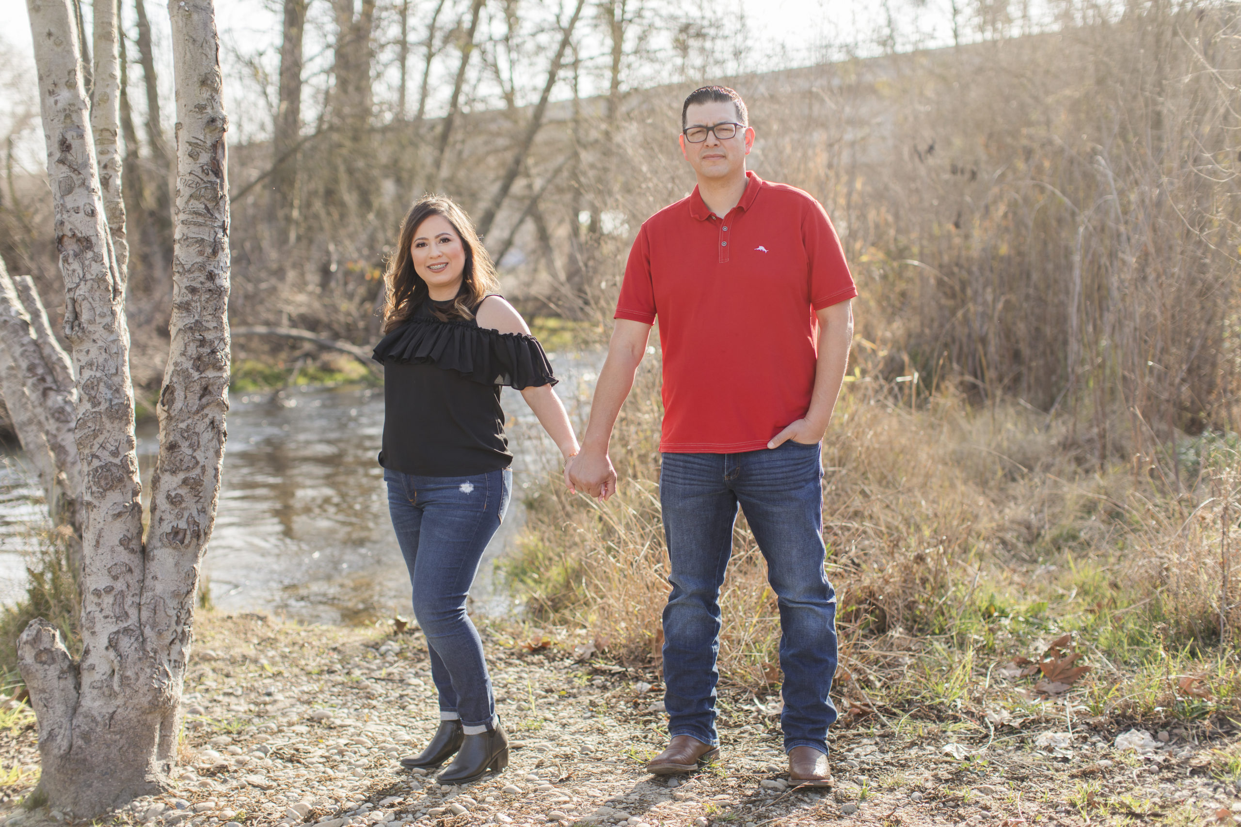 engaged couple by creek
