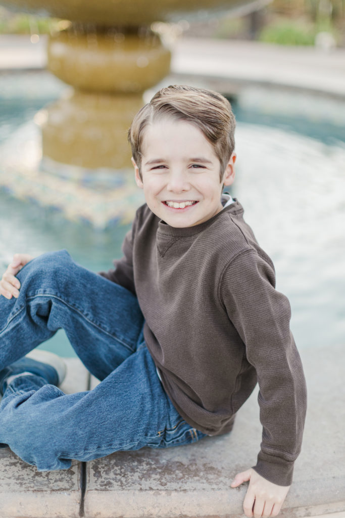 Boy sitting on fountain at Harlan Ranch