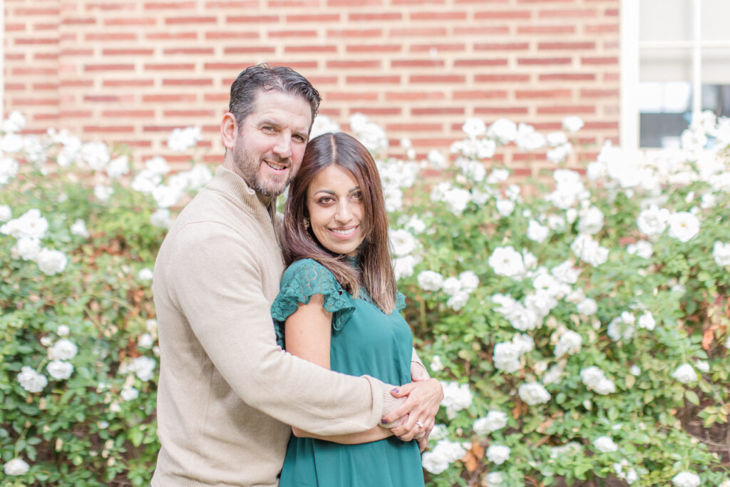 Couple posing in front of roses